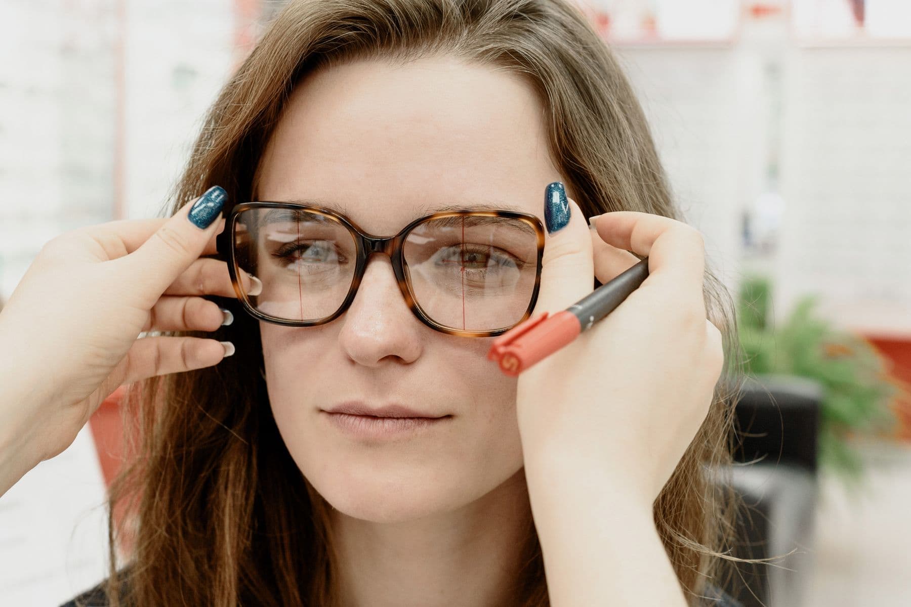 Óptica comprobando las lentes en la montura de una clienta