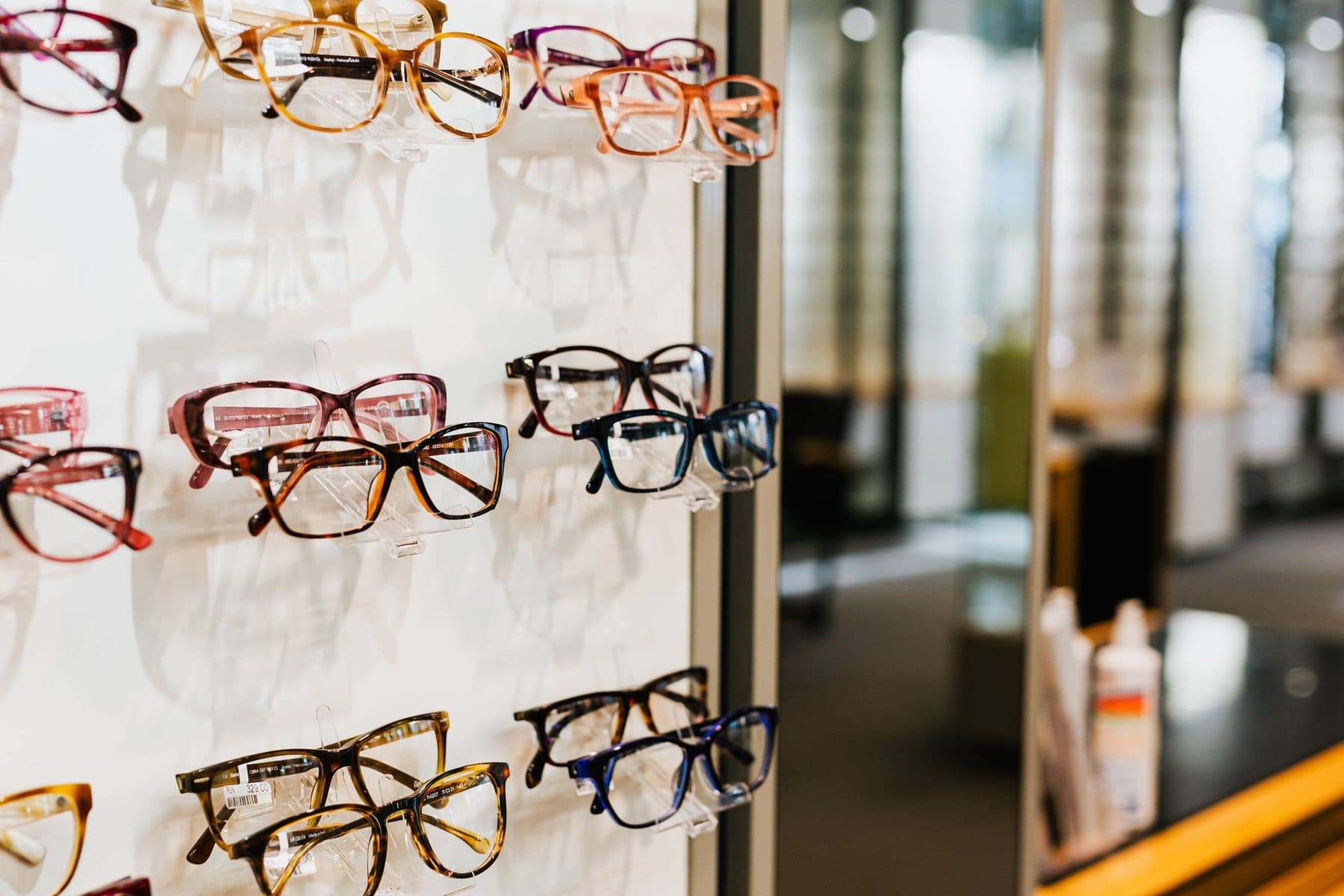 Monturas de gafas expuestas en una estantería de cristal