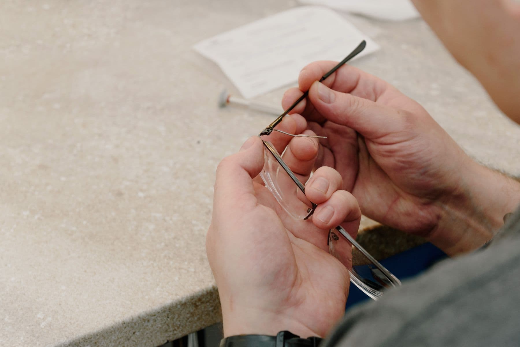 Óptico ajustando una montura en el taller